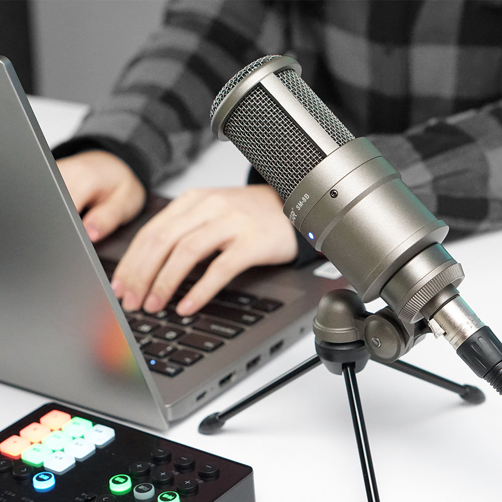 Takstar SM-8B Studio Recording Condenser Microphone on a tripod next to a laptop and a SC-M1 sound card